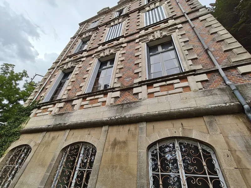 Tall arched ground-floor windows with their original ironwork