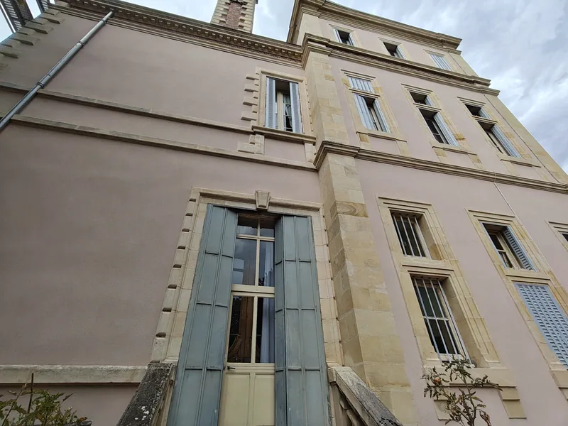 A tall shuttered window set in dressed stone