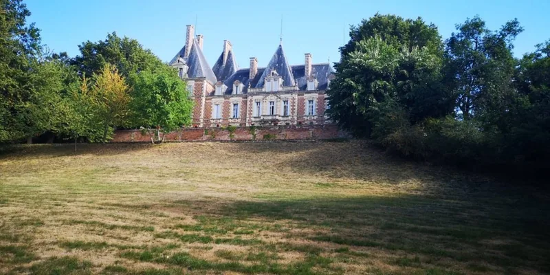 The chateau seen across a wide meadow