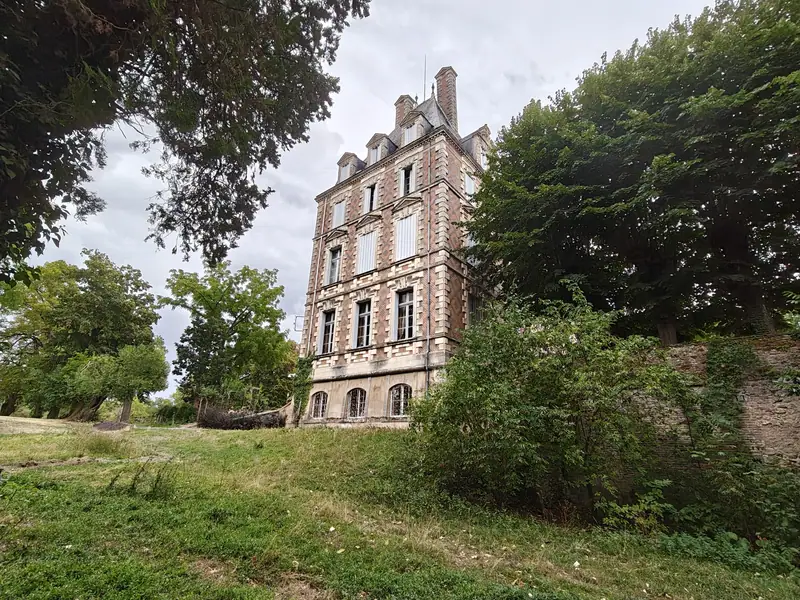 The corner pavilion rising above overgrown parkland