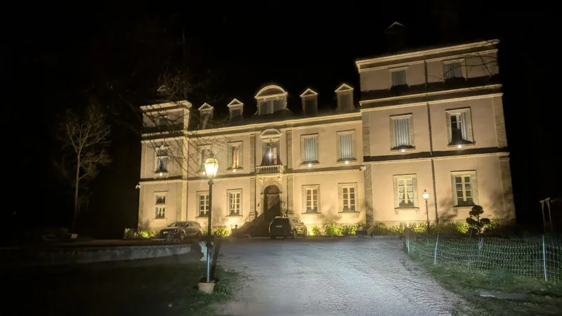 The chateau at night, its facade washed in warm light