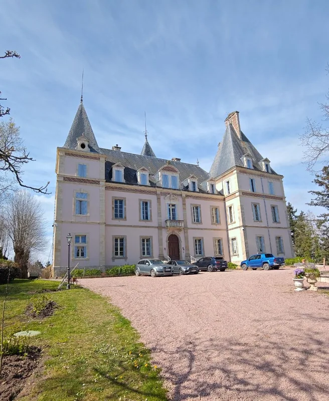 The chateau front seen up the gravel drive in spring