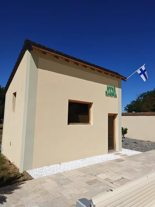 The Finnish sauna building, flag flying, beside the pool terrace